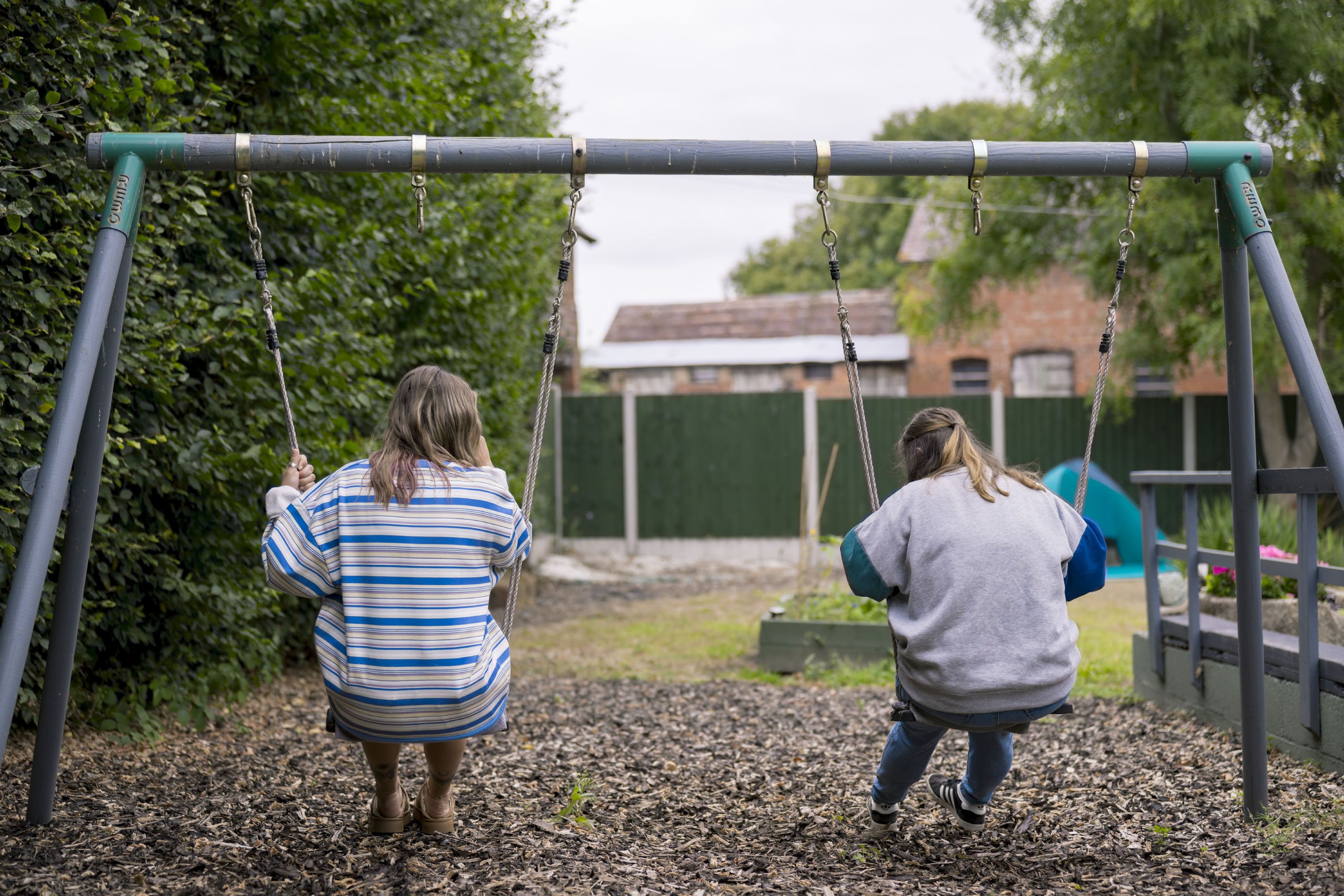 Image of carer looking at child reading a book