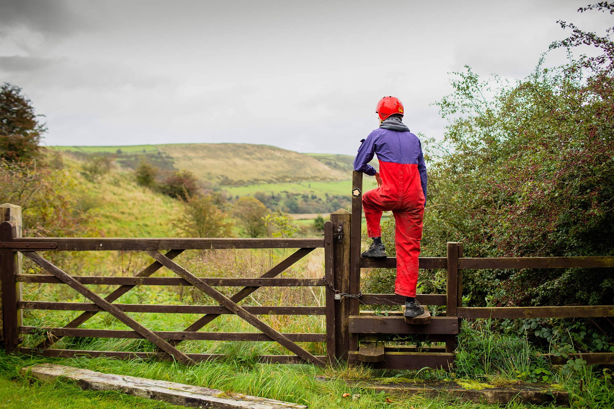 Image of young person in climbing gear looking out over hills